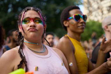 Gökkuşağı makyajı ve aksesuarlı iki genç kadın, Igbtq hakları için kimliklerini ve desteklerini ifade ederek gurur festivalinin tadını çıkarıyorlar.