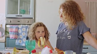 Sevgi dolu bir anne, genç kızı izliyordu. Sabah aile kahvaltısı sırasında muzdan zevk alıyordu.