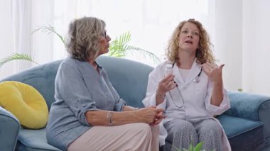 Doktor, ev ziyareti sırasında kıdemli hastaya ilaç reçetesini açıklıyor. Yavaş çekim videosu