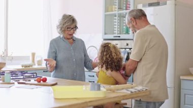 Büyükbabalar torunlarını sevgiyle okula hazırlar. Sırt çantasını parlak bir mutfakta ayarlarlar. Yavaş çekim