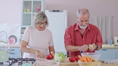 Yaşlı bir çift evcil bir mutfakta sebze soyuyor ve kesiyor, birlikte vakit geçiriyorlar.