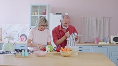 Üst düzey bir çift modern mutfaklarında sağlıklı bir salata hazırlıyor. Yavaş çekim