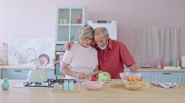 Kıdemli çift birlikte vakit geçiriyorlar, mutfakta sebze kesiyorlar, yavaş çekimde çekiyorlar.
