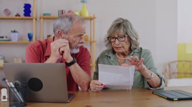 Endişeli yaşlı çift mektubu kötü haberlerle okuyor, hayal kırıklığıyla ve yavaş çekimde endişeleniyor.