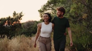Altın saat boyunca manzaralı patikada birlikte yürüyen çok ırklı genç gezginler, minibüs hayatı yolculuğu ve açık hava keşfi özgürlüğünü kucaklarken samimi bir bağ anlarını paylaşıyorlar.