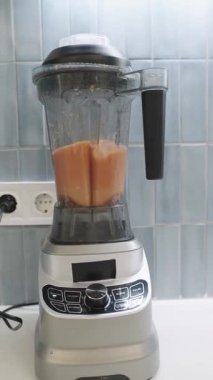 Modern electric blender mixing ingredients for a healthy breakfast. Close up of a kitchen appliance preparing a fresh vitamin fruit drink