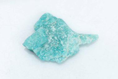 Beyaz arka planda izole edilmiş doğal Amazon mücevheri. Arka planda mavimsi yeşil bir kristal. Potasyum feldspat mikro-cline çeşitleri