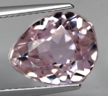 Gri arka planda doğal taş kunzite.