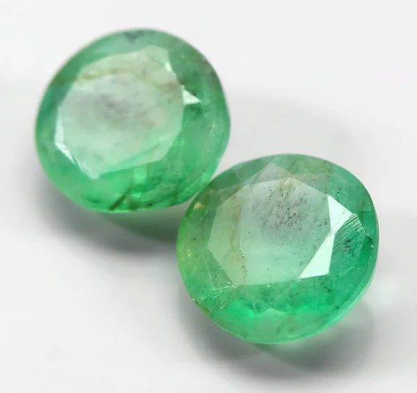 Natural gemstone green emerald on a gray background