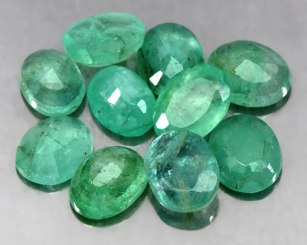 Natural stone green emerald on a gray background