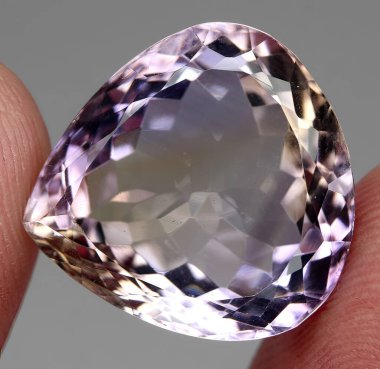 Natural gem bicolor ametrine on a gray background