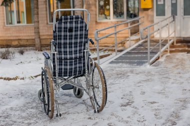 Empty wheelchair in the hospital on the ramp. Wheelchair close-up. Childrens wheelchair.