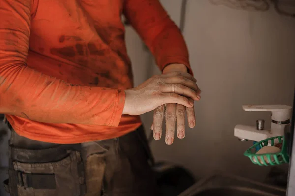 The mechanic washes his hands after car repair. Man washing his hands