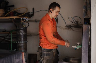 Araba tamirinden sonra araba tamircisi ellerini yıkıyor. İşçi ellerini yıkar.