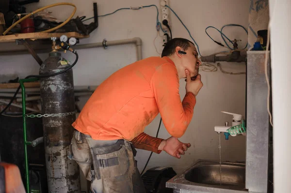 Auto mechanic washing his hands after car repair. Worker washes his hands