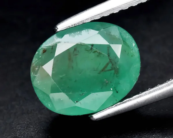 Natural gem green emerald on gray background