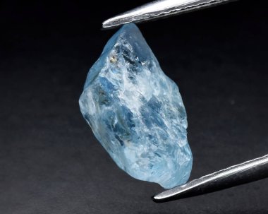 Gri arkaplanda doğal mavi akuamarin mücevheri