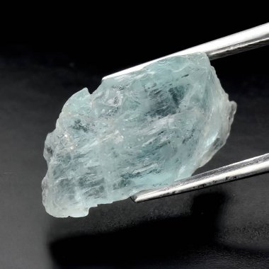 Gri arkaplanda doğal mavi akuamarin mücevheri