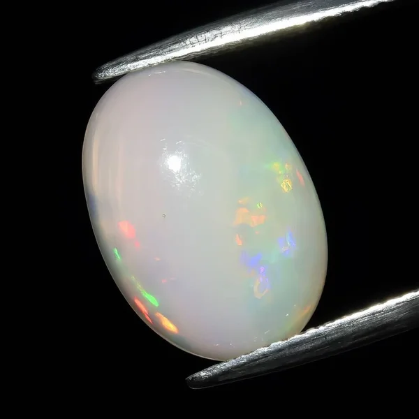 stock image Natural precious stone opal on a black background
