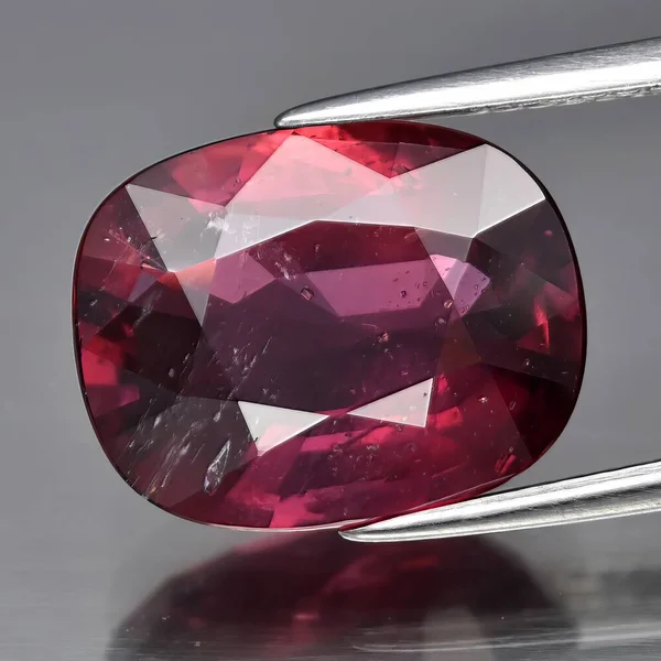 Natural gem red ruby on gray background
