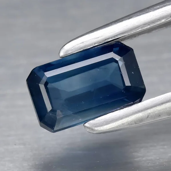 Natural gem blue sapphire on gray background
