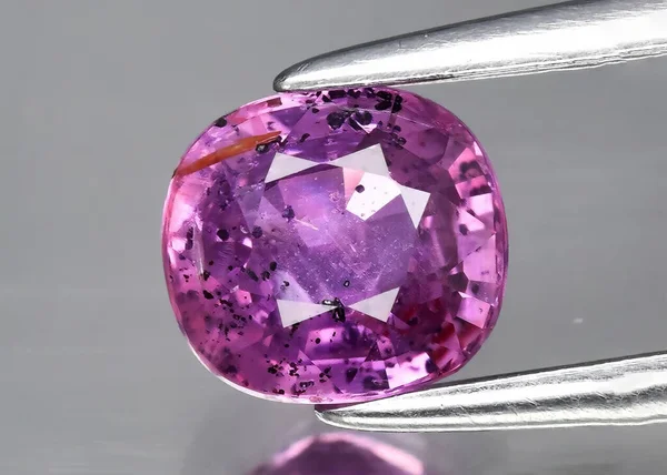 Natural gem purple sapphire on gray background