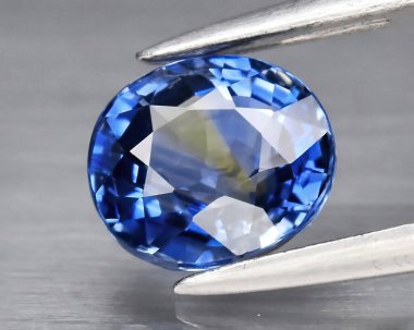 Natural gem blue sapphire on gray background