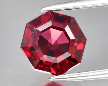 Gri arkaplanda doğal kırmızı rodolit taşı.