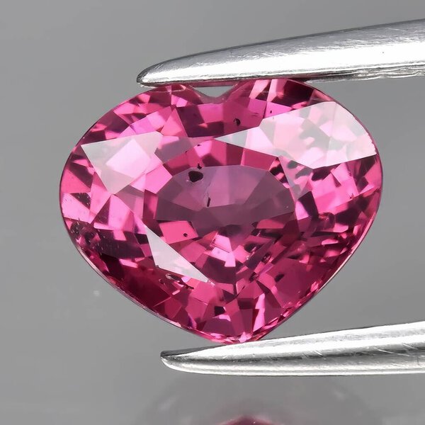 Natural gem red rhodolite garnet on gray background