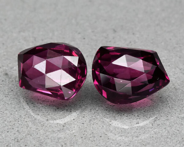 Natural gem red rhodolite garnet on gray background