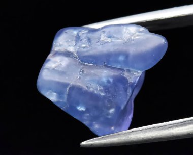 Natural gem blue tanzanite on gray background