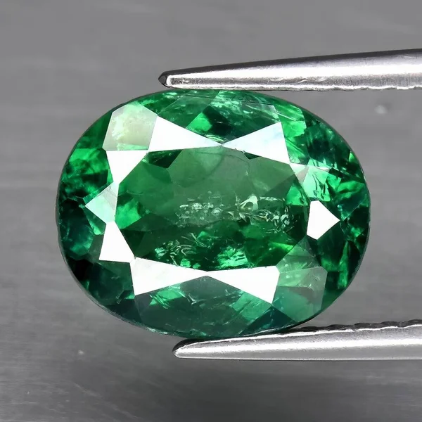 Natural gem green topaz on a gray background