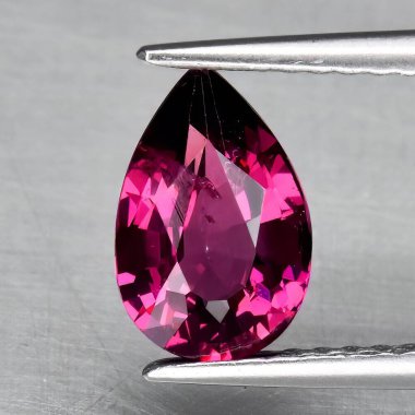 Gri arka planda doğal değerli taş kırmızısı rodolit taşı.