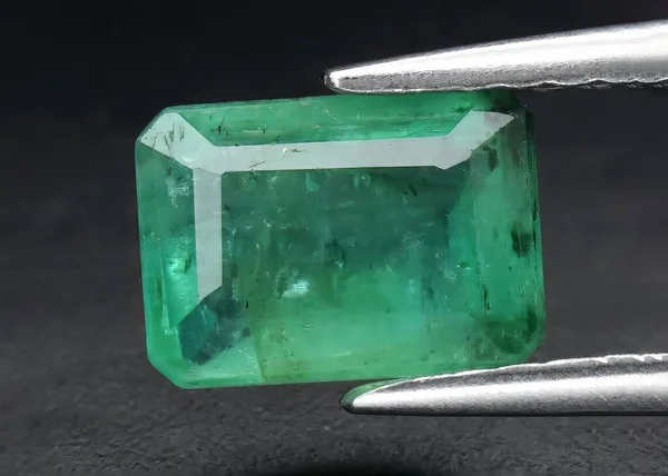 Natural gem green emerald on gray background