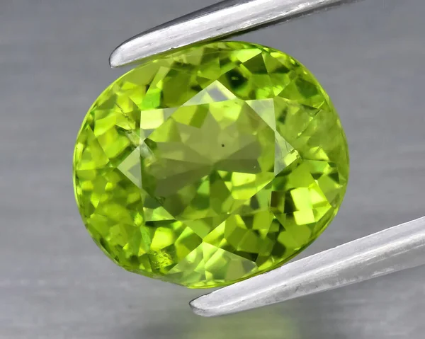 灰色の背景に天然宝石緑のペリドット — ストック写真