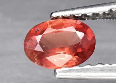 Gri arkaplanda doğal turuncu Padparadscha safiri