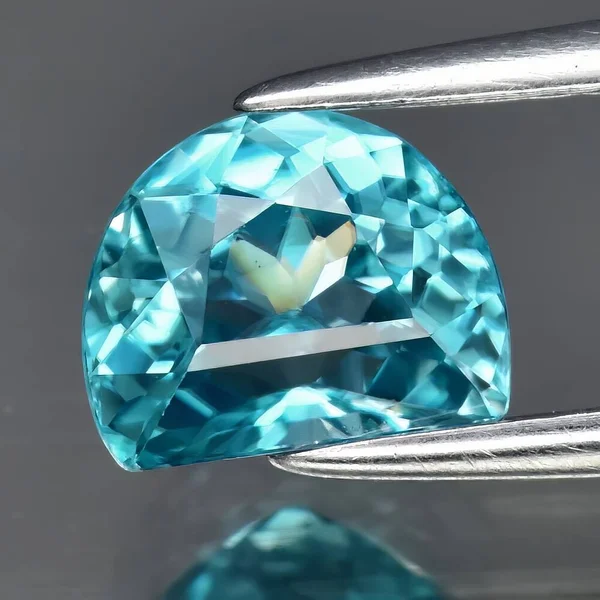 グレーの背景に自然な青ジルコンの宝石 — ストック写真