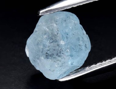 Gri arkaplanda doğal mavi akuamarin taşı