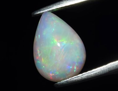 Natural precious stone noble opal on a black background clipart