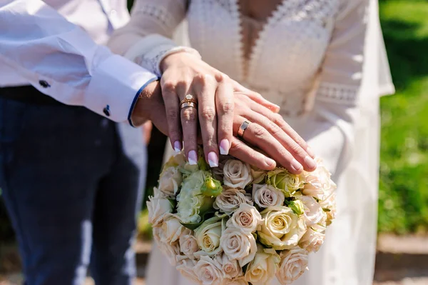 Bröllopsringar Händerna Nygifta Bukett Blommor Bakgrunden Guldringar Man Och Kvinna — Stockfoto