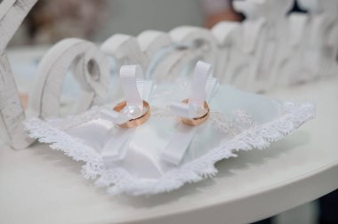 Beyaz bir yastık üzerinde iki altın alyans