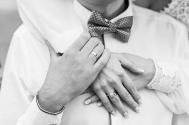 Yeni evlilerin elinde evlilik yüzükleri var. Bir erkek ve bir kadının elinde altın yüzükler