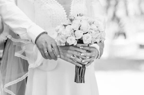 A bouquet of white flowers in the hands of the bride. Bride\'s bouquet of white flowers in the hands of a woman