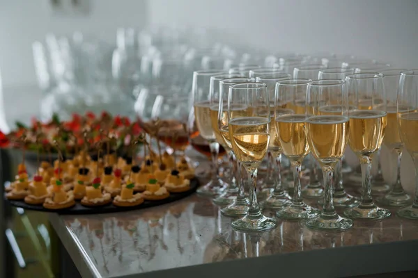 stock image Festive buffet. Glasses of white champagne, glasses of cognac, red wine. Canape with cheese and olives on a skewer