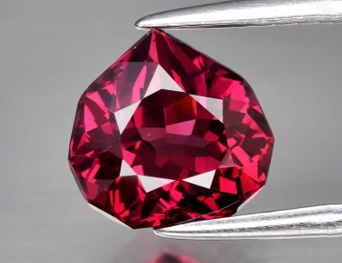 Beyaz arka planda doğal değerli taş kırmızısı rodolit taşı.