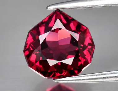 Beyaz arka planda doğal değerli taş kırmızısı rodolit taşı.