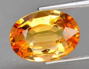 Gri arkaplanda doğal sarı safir.