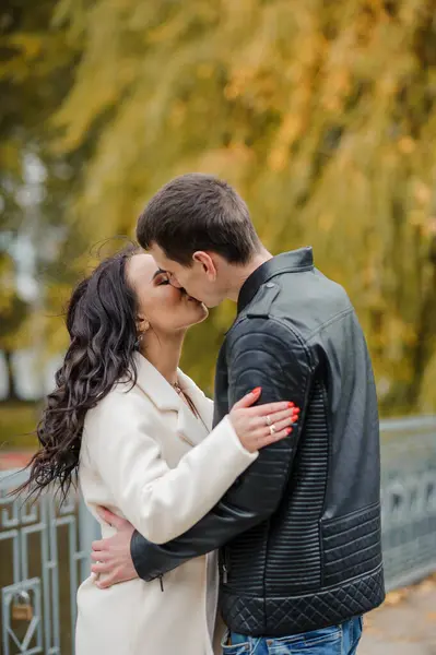 남자가 임신한 아내를 안아준다 재킷을 남자는 코트를 여자를 키스합니다 가을에 — 스톡 사진
