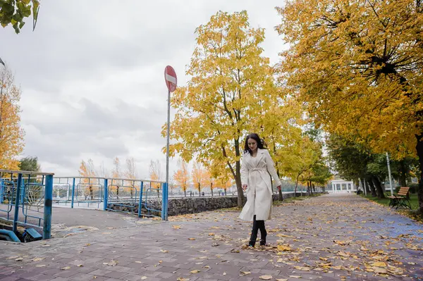 秋天公园里穿着白色外套的布鲁内特女孩 — 图库照片