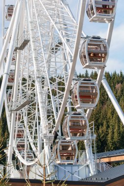 Bukovel 'de mavi gökyüzünün önünde büyük, uzun, beyaz dönme dolap. Karpatlar